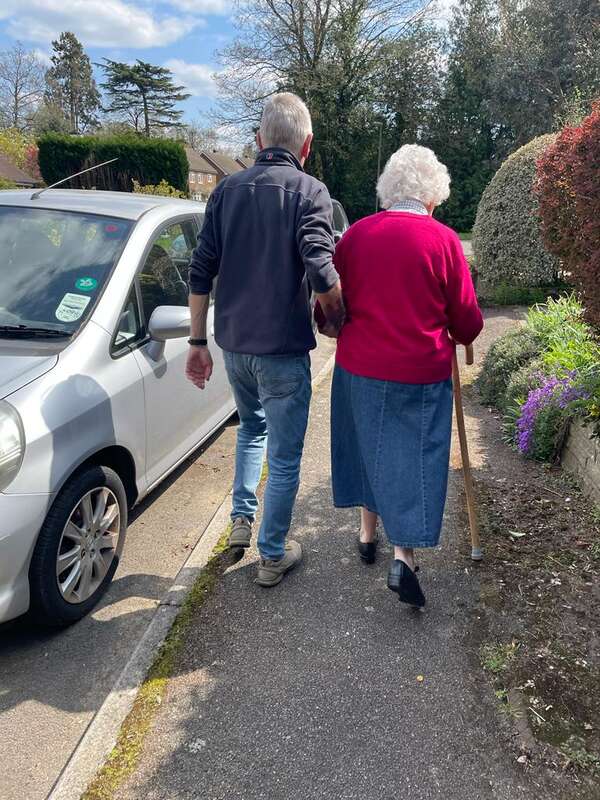 Volunteer helps client to car